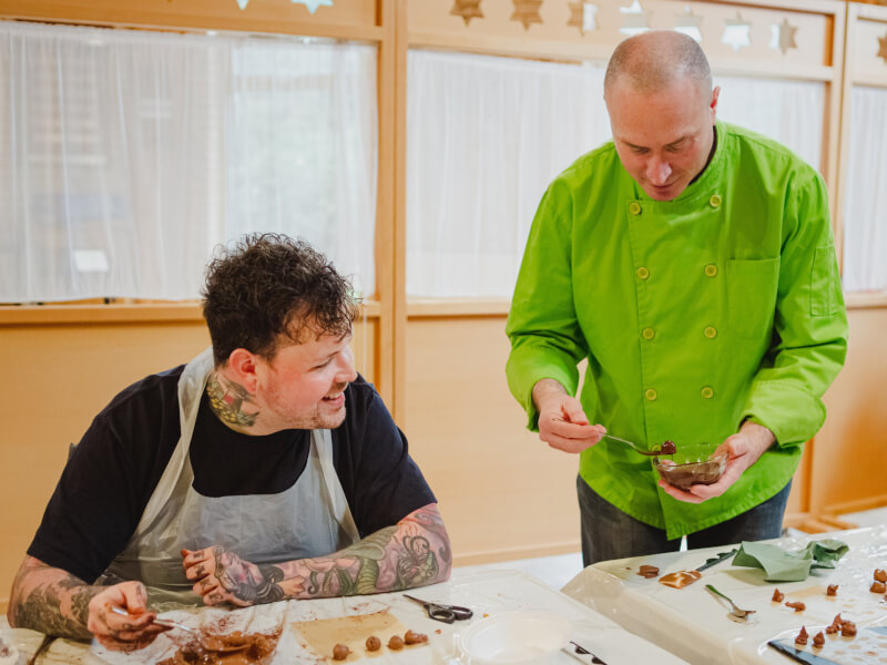 Raanan from r&amp;m Fine Chocolate shows a student how to make handmade chocolate truffles